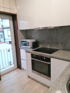 a kitchen with a stove and a microwave at B in Caminha in Caminha