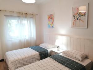 two twin beds in a room with a window at B in Caminha in Caminha