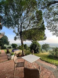 - une table et des chaises sur une terrasse en brique avec un arbre dans l'établissement Heritage mountain top Villa near Rome w/ Pool & Panoramic views, à Poli