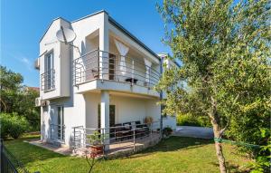 ein weißes Haus mit einem Balkon und einem Hof in der Unterkunft Pet Friendly Home In Bibinje With Kitchen in Bibinje
