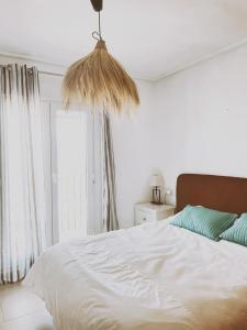 Un dormitorio con una gran cama blanca y una ventana en Haciënda Riquelme Golf Atlantico 2 bedroom apartment, en Sucina
