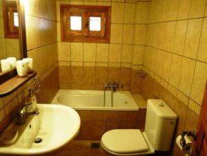 uma casa de banho com um lavatório, um WC e uma banheira em Ikosimo Guesthouse em Milína
