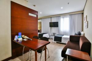 a hotel room with a desk and a bed at Transamerica Executive Chácara Santo Antônio in São Paulo