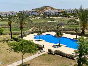 een luchtzicht op een resort met een zwembad en palmbomen bij Haciënda Riquelme Golf Atlantico 2 bedroom apartment in Sucina