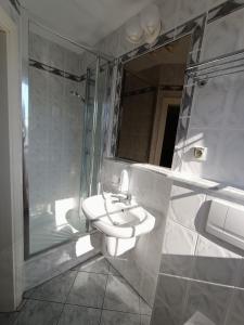 a bathroom with a sink and a shower and a mirror at Apartamenty Hexagon nr 32 in Grzybowo