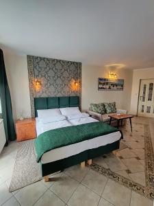 a bedroom with a large bed and a couch at Apartamenty Hexagon nr 32 in Grzybowo