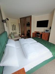 a large white bed in a room with a television at Apartamenty Hexagon nr 32 in Grzybowo