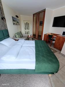 a large white bed in a room with a couch at Apartamenty Hexagon nr 32 in Grzybowo