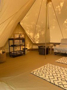 ein Zelt mit einem Tisch und einem Teppich in einem Zimmer in der Unterkunft Mazurskie Chatki in Mrągowo