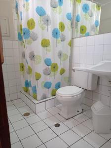 a bathroom with a toilet and a shower curtain with umbrellas at Luxor in Arequipa