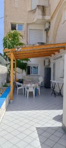 patio ze stołem i krzesłami przed budynkiem w obiekcie Aria di Mare w mieście Noto Marina