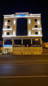 um edifício com luzes ao lado de uma rua em White House Apartments em Khamis Mushayt
