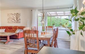 ein Wohnzimmer mit einem Tisch, Stühlen und einem Sofa in der Unterkunft 3 Bedroom Gorgeous Home In Tanumshede in Tanumshede