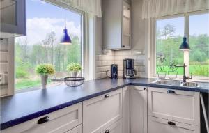 a kitchen with white cabinets and a large window at 3 Bedroom Gorgeous Home In Tanumshede in Tanumshede