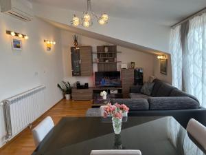 a living room with a couch and a table with flowers at Luxury apartman Iris in Hvar