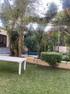a white bench in a yard with palm trees at The grand palm in Pretoria