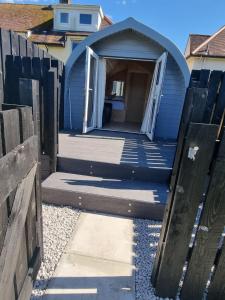 a blue house with a gate and a door at Caledonian Pod. In Caol, Fort William in Caol