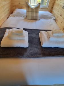 um quarto com duas camas com toalhas brancas em Caledonian Pod. In Caol, Fort William em Caol