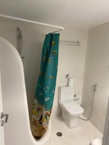 a bathroom with a toilet and a shower curtain at Bianco e Azzuro in Vouliagmeni Lake