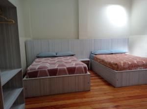 two beds in a room with wooden floors at Luxor in Arequipa