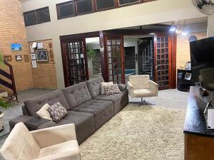 uma sala de estar com um sofá e uma cadeira em Pousada Querência Maceió em Maceió