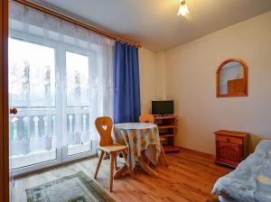 ein Wohnzimmer mit einem Tisch und einem Fenster in der Unterkunft Pokoje gościnne u Bożenki in Krościenko nad Dunajcem