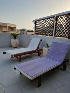 two lounge chairs sitting on a rooftop patio at Nuovo attico con terrazza 5 minuti dal mare in Cagliari