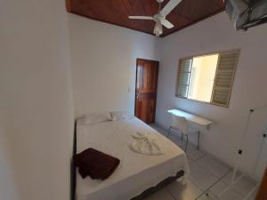 a bedroom with a bed and a table and a window at Novo Hotel in Itajubá