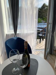 a bottle of wine and two glasses on a table at Dom gościnny Jarek in Rowy