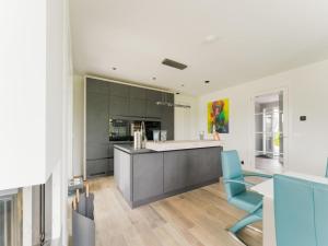 a kitchen with a counter and a blue chair at Peaceful and luxurious villa at the waterfront in Stavoren in Stavoren