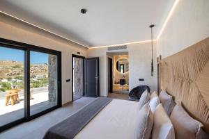a bedroom with a large bed and a large window at Tropicana Hotel , Suites & Villas Mykonos in Paradise Beach