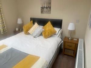 a bedroom with a bed with yellow pillows on it at THE CARRIAGE HOUSE in Woodhorn