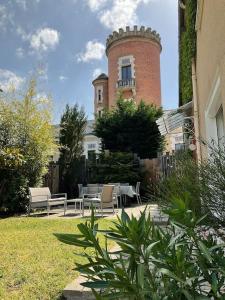 - un bâtiment avec une tour dotée d'une table et de chaises dans l'établissement Maison indépendante, domaine VICHY LA TOUR, à Abrest 15 autres photos