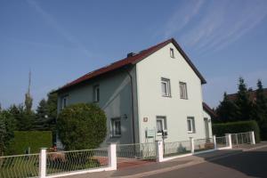 une maison blanche avec un toit rouge dans l'établissement Apartment Schinkmann, à Bad Frankenhausen