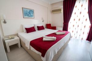 a bedroom with a large bed with red pillows on it at Ayapam Hotel in Pamukkale