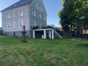 een groot wit huis met een grote tuin bij Mein Eifel Ferienhaus Altes Pfarrhaus in Dahlem