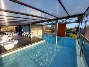 una gran piscina con sillas y un edificio en Costalago Suites- By HVH en Villa Carlos Paz