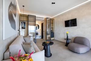 a living room with a couch and a chair at Tropicana Hotel , Suites & Villas Mykonos in Paradise Beach