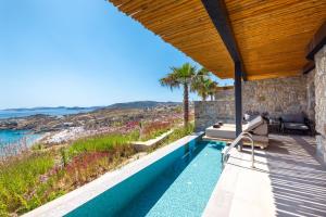 a house with a swimming pool with a view of the ocean at Tropicana Hotel , Suites & Villas Mykonos in Paradise Beach