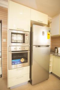 eine Küche mit einem Kühlschrank aus Edelstahl und einem Backofen in der Unterkunft Accra Luxury Homes @ East Legon in Accra
