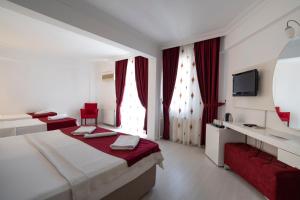 Habitación de hotel con cama y TV en Ayapam Hotel, en Pamukkale