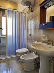 ファヴィニャーナにあるCasa Relax Acqua Marinaのバスルーム(トイレ2つ、シンク、シャワー付)