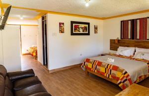 - une chambre avec un lit et un canapé dans l'établissement Tambo Lodge Canta, à Canta