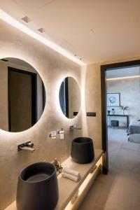 a bathroom with a sink and a large mirror at Tropicana Hotel , Suites & Villas Mykonos in Paradise Beach