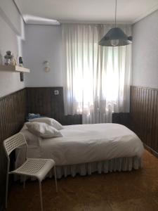 um quarto com uma cama grande e uma janela em Apartamento Torrelavega em Torrelavega