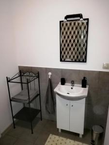 a bathroom with a white sink and a chair at Apartament Janka in Zator