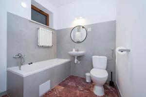 a bathroom with a tub and a toilet and a sink at Krynica Zamkowa 48 in Krynica Zdrój +8 photos