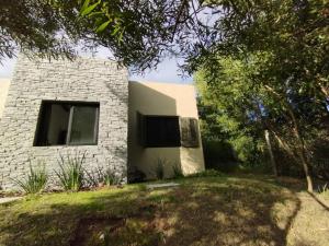a stone house with a window and a yard at Arazá in Cuchilla Alta