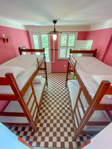 two bunk beds in a room with a checkered floor at Refugio Hostel Fortaleza in Fortaleza