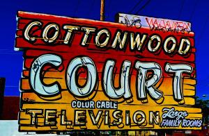 a sign for a colmont gourmet colincial center at Cottonwood Court Motel in Santa Fe